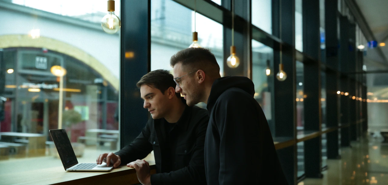 Dragos and Bogdan reviewing code on a laptop